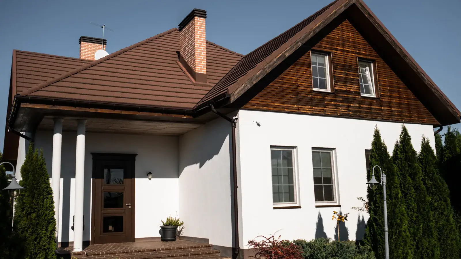 Dom jednorodzinny z zadbanym ogrodem w słoneczny dzień